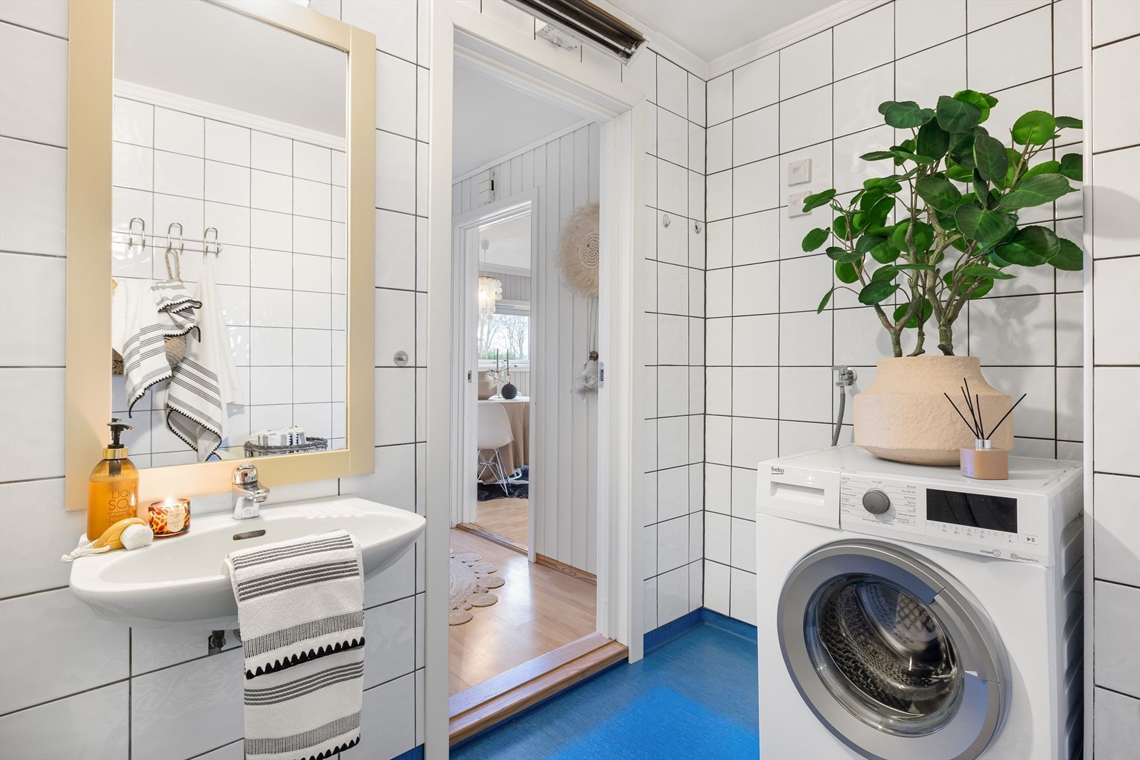 Bad med flislagte vegger og belegg på gulvet. Badet varmes opp med elektrisk stråleovn. Galleribilde