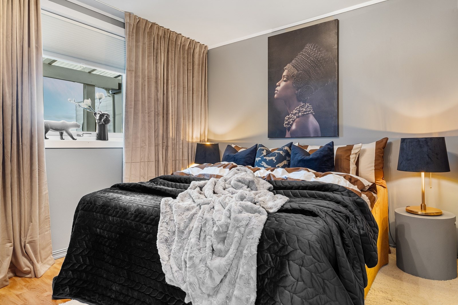 Leiligheten har et delikat soverom malt i en lys gråtone. Galleribilde