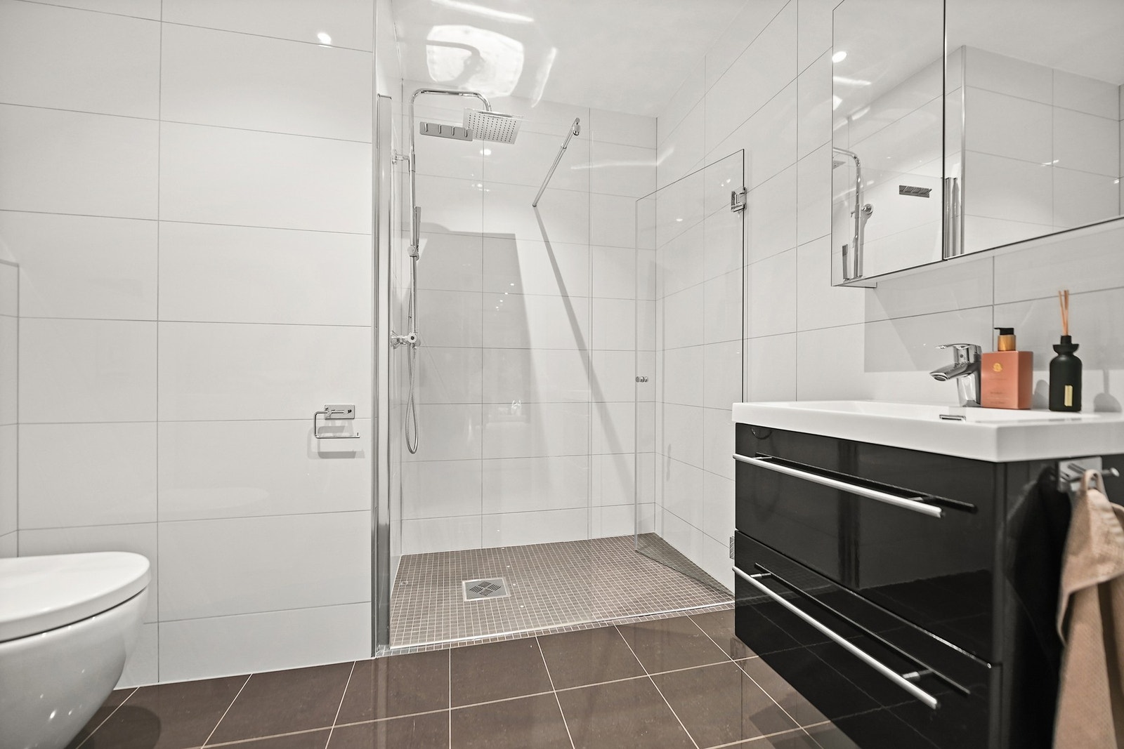 Pent baderom med varmekabler, stor dusjnisje og pen innredning. Galleribilde