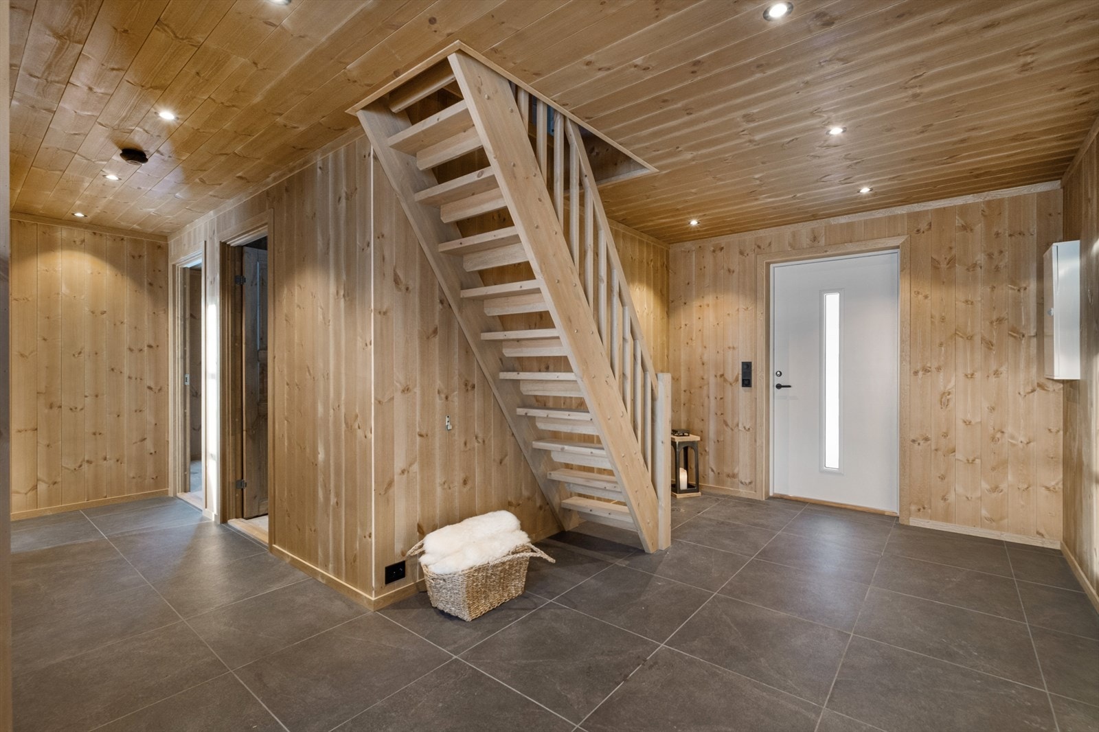 Romslig entré med fliser på gulv, gulvvarme og god plass til yttertøy Galleribilde