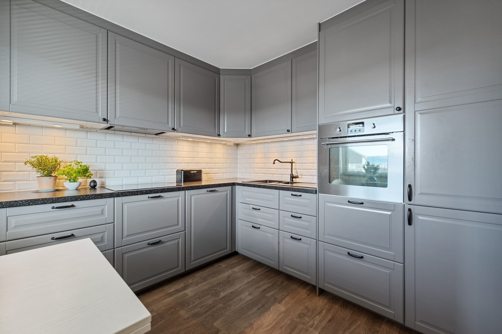 Kjøkkenet byr på flere flotte detaljer som blant annet hvitevarer, vask, pene og moderne fargevalg og gode oppbevaringsmuligheter. Rikelig med benk- og skapplass da innredningen har en strategisk plassering med en gjennomtenkt og nøye planlagt utforming. Galleribilde