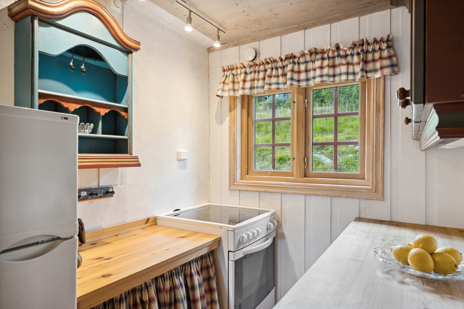 Innredningen har frittstående komfyr og kjøleskap. Det er naturlig avtrekk fra kjøkkenet via veggventil og åpning i vindu. Galleribilde