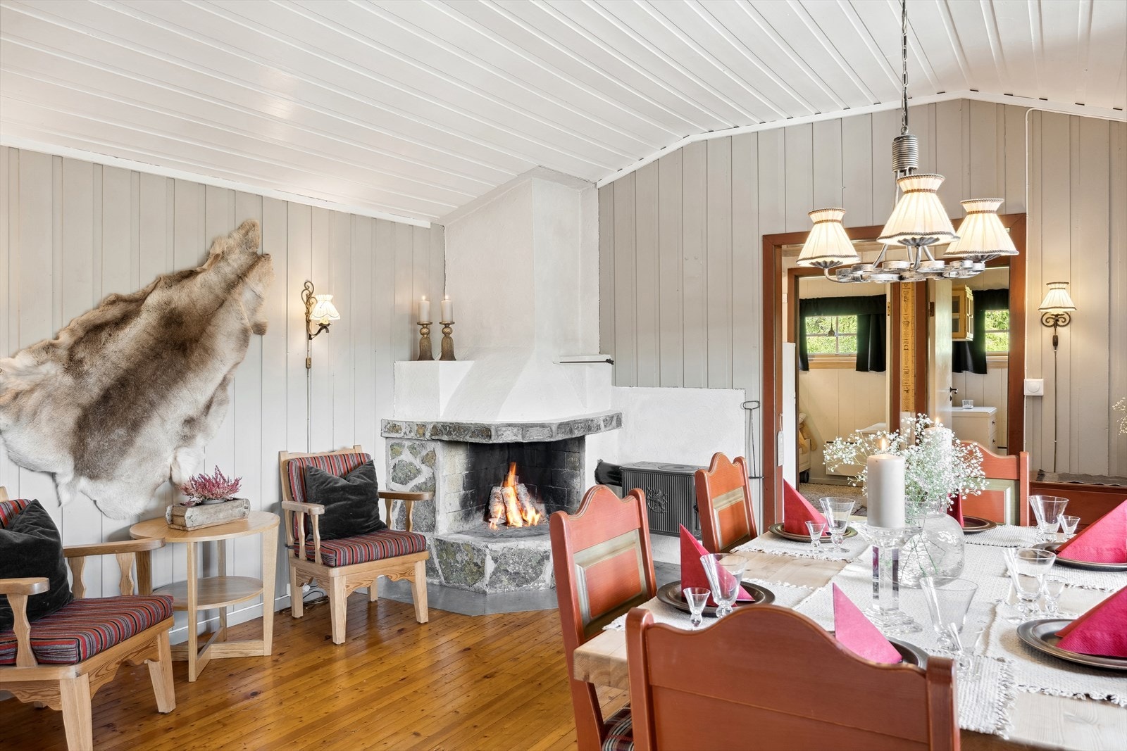 En hvit, stilren peis forblendet med naturstein er med på å gi den perfekte hyttestemningen, og en vedovn sørger for ekstra varme på kalde dager. Galleribilde