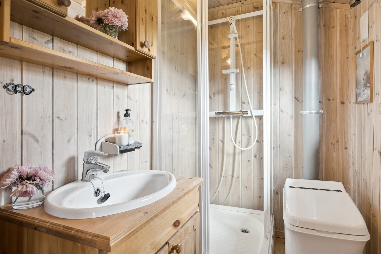 Badet har benkeskap i heltre med nedfelt servant, dusjkabinett i hjørne og Cinderella forbrenningstoalett. Galleribilde