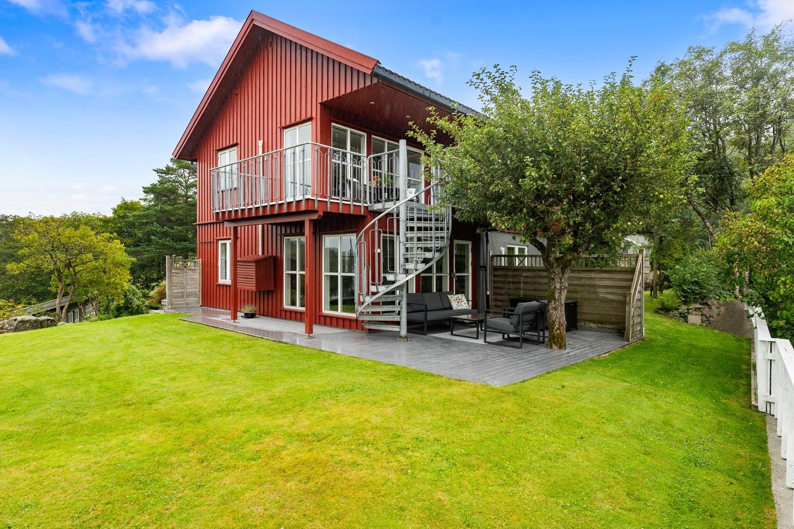 Tomten er flott opparbeidet med plen, frukttrær, busker og beplantning. Galleribilde