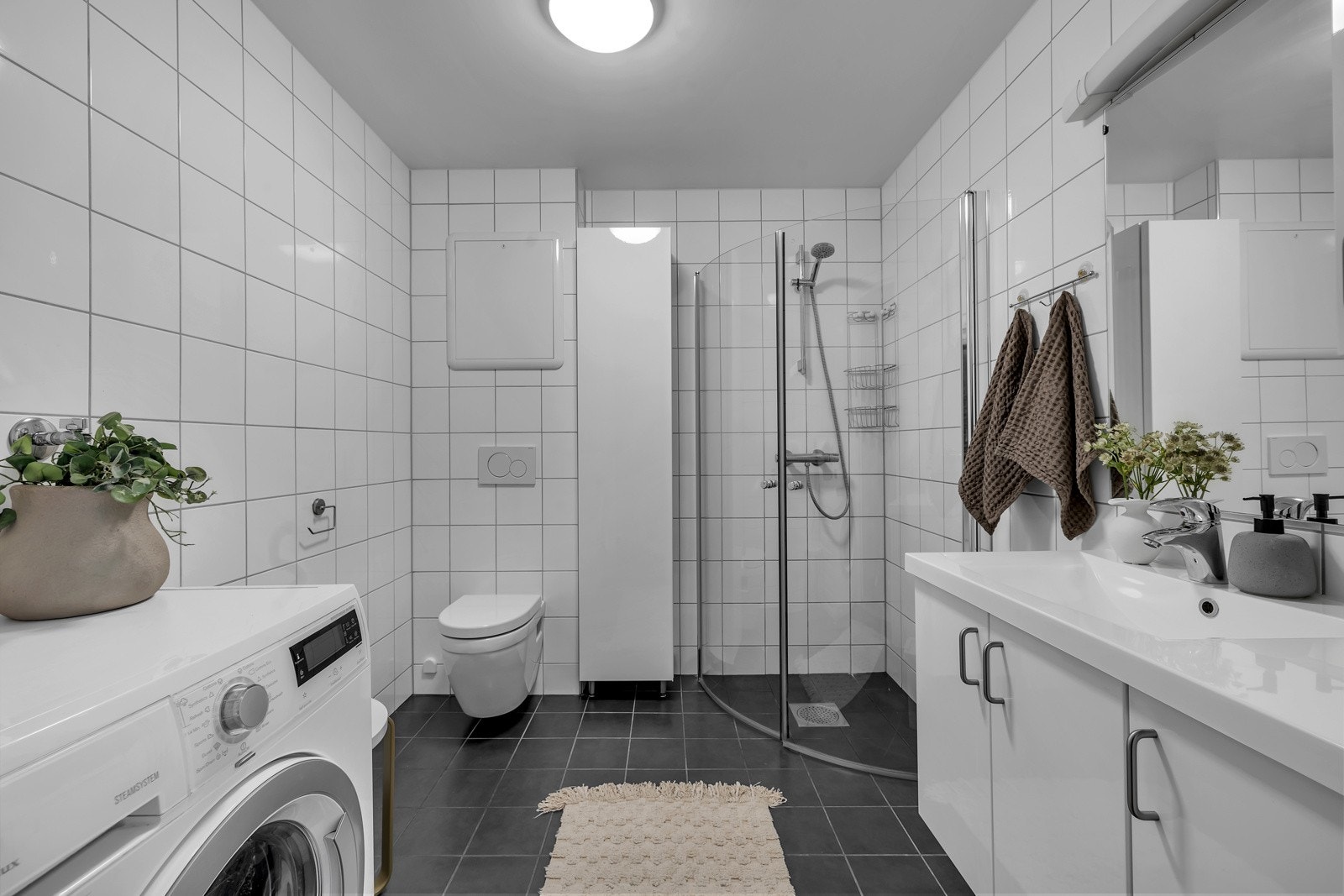 Innfellbare glassdører i dusjsone, opplegg for vaskemaskin og tørketrommel m.m. Galleribilde