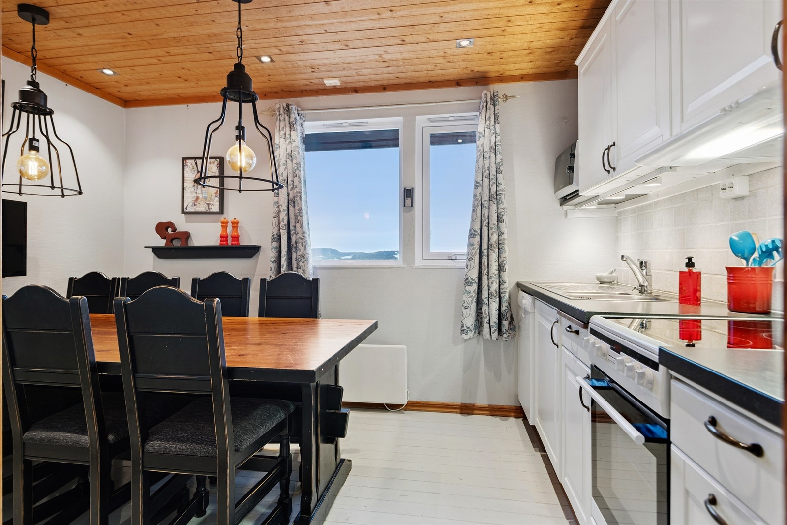 Lyst og pent kjøkken med en hyggelig spiseplass. Galleribilde