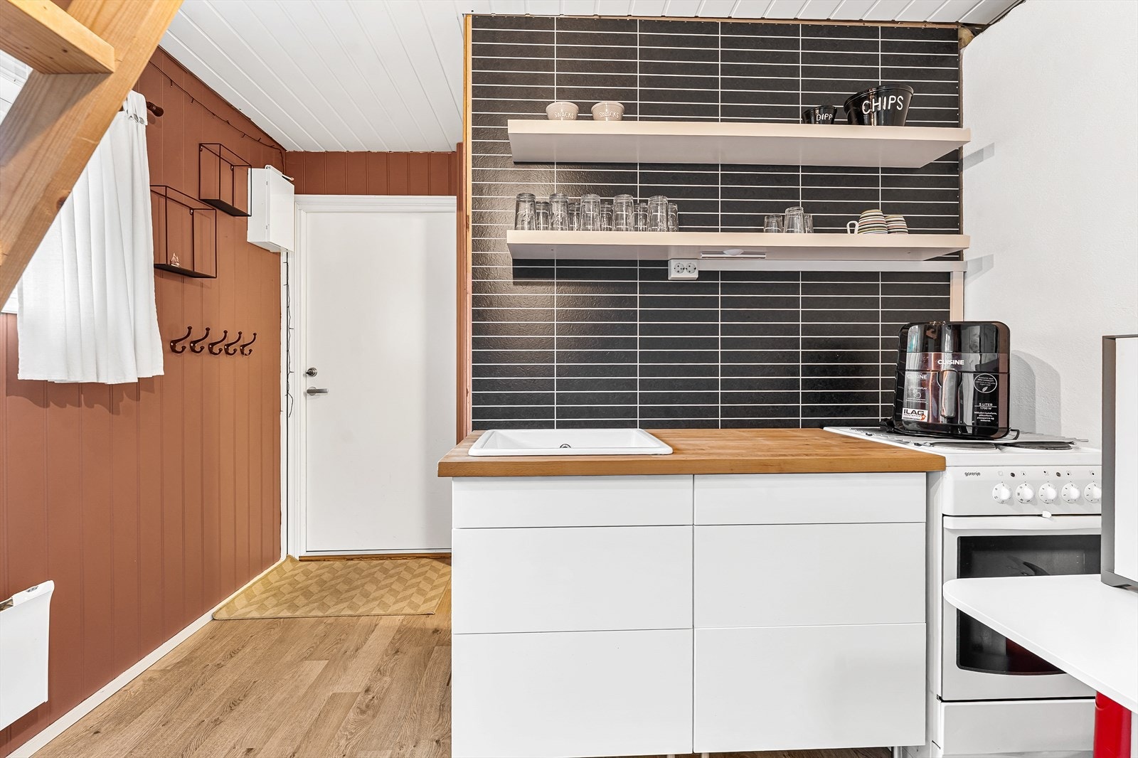 Uthuset har en liten kjøkkeninnredning m/komfyr Galleribilde