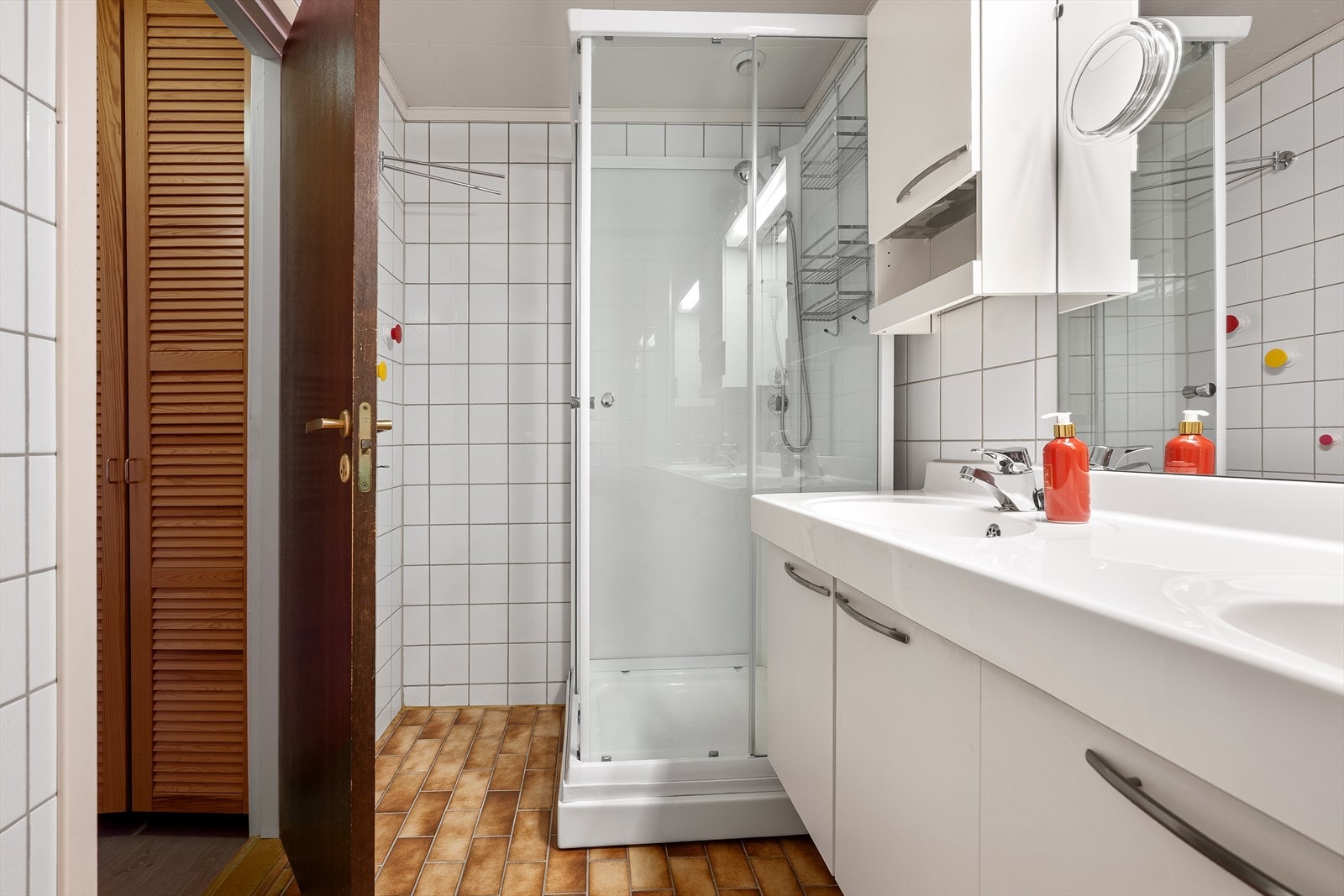 Badet er utstyrt med servantinnredning, speil, dusjkabinett, opplegg for vaskemaskin og innebygget varmtvannsbereder Galleribilde