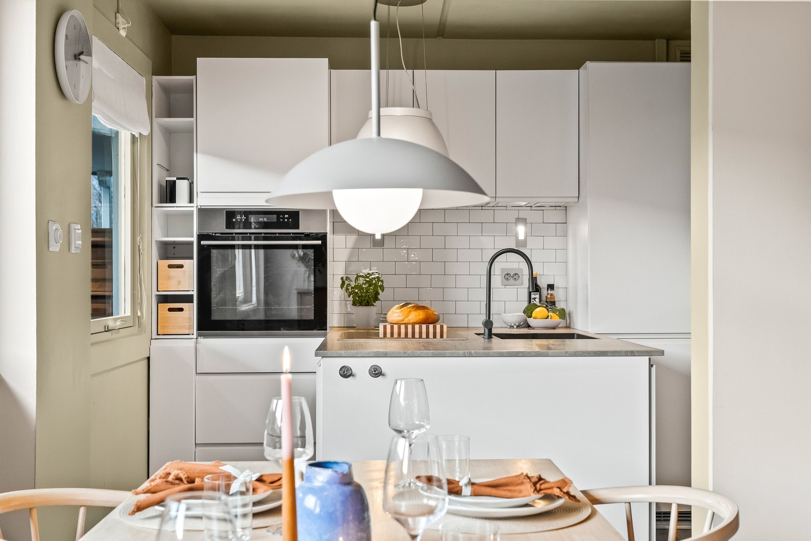 Pent kjøkken med innredning fra KVIK, med hvite fronter med gripelist. Galleribilde