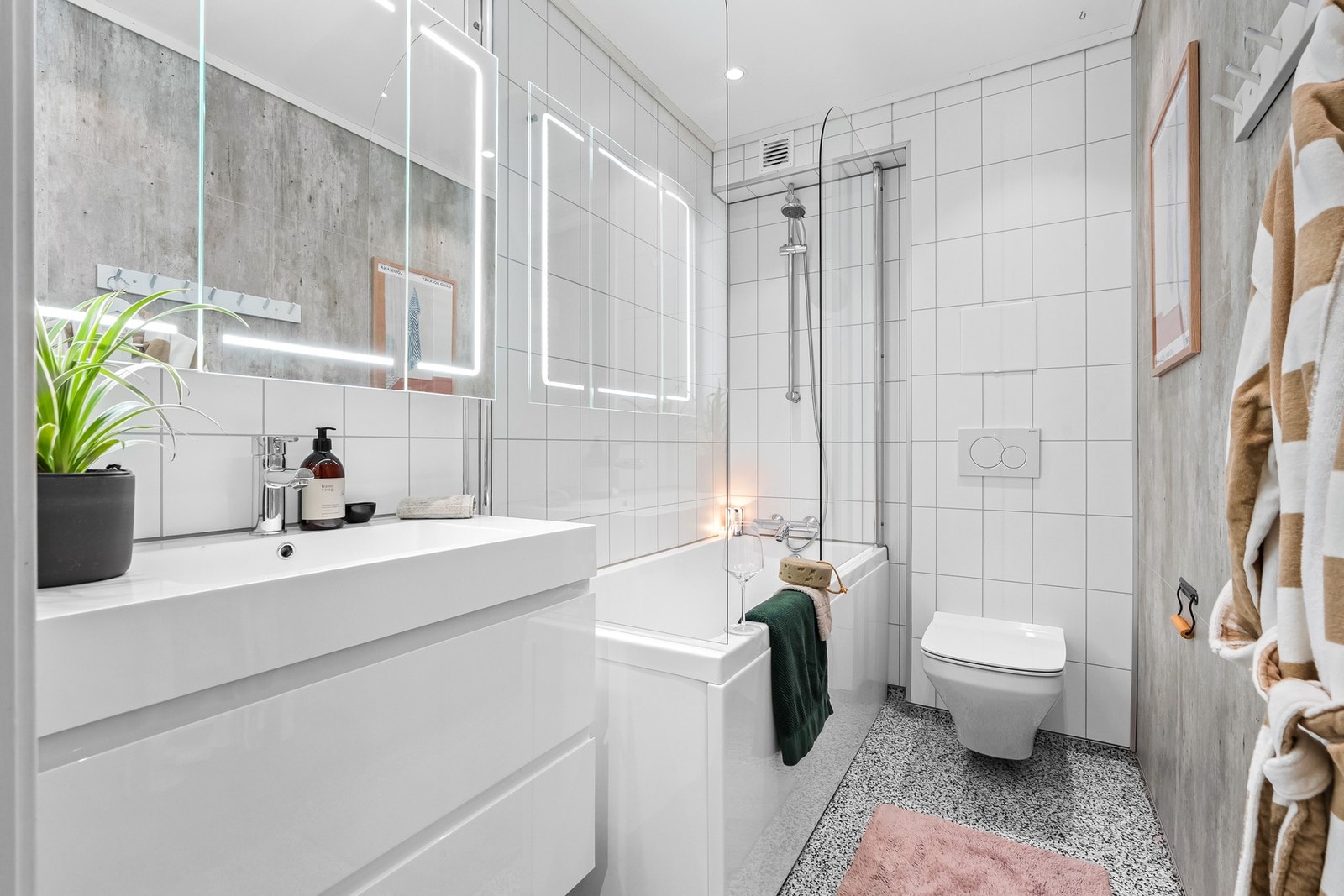 Pent baderom, med downlights i himling og varme i gulv. Badet er innredet med moderne baderomsmøblement og badekar, Galleribilde