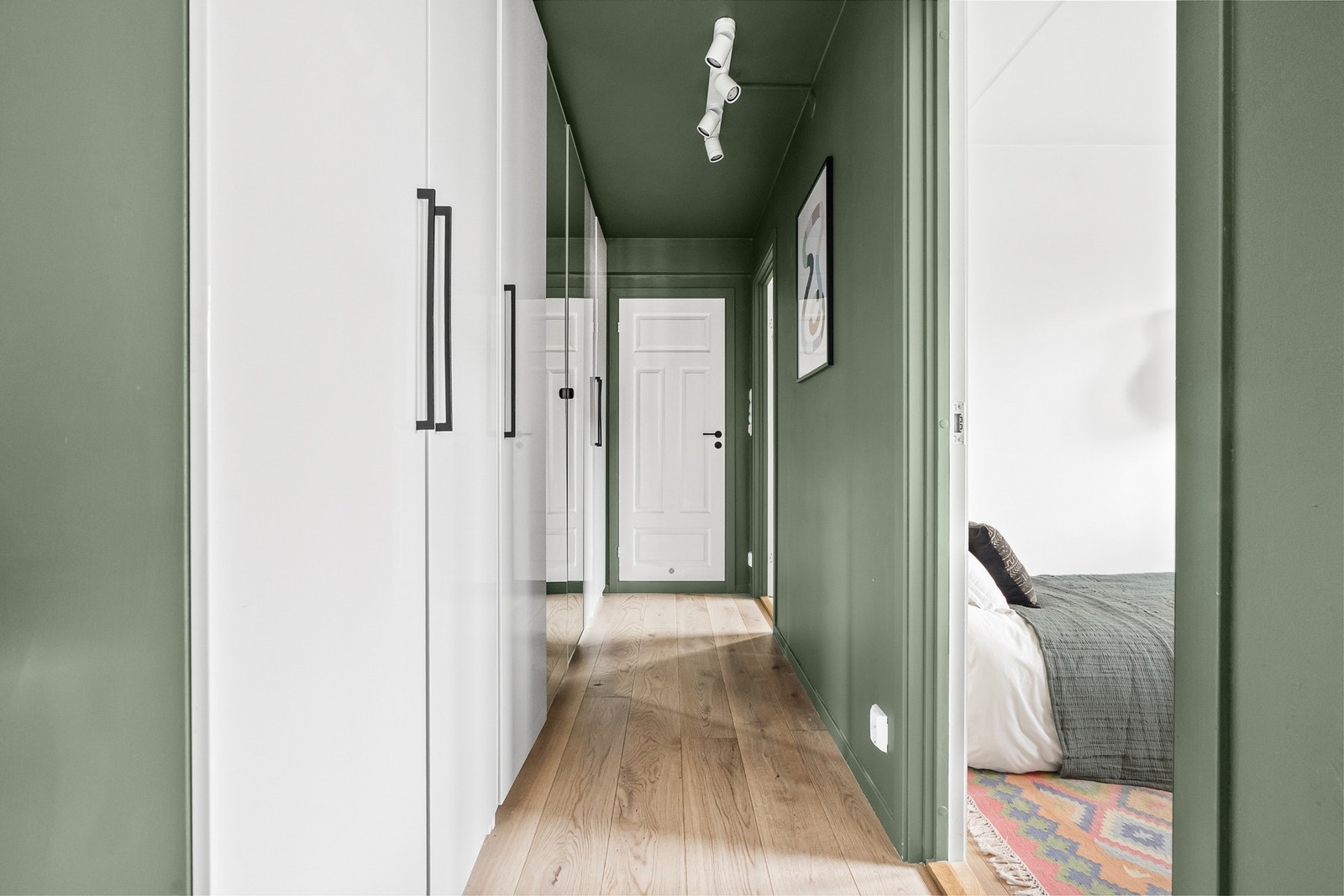 I gangen utenfor soverommene er det montert en lang skaprekke, med delvis hvite høyglansfronter og speilfronter. Galleribilde