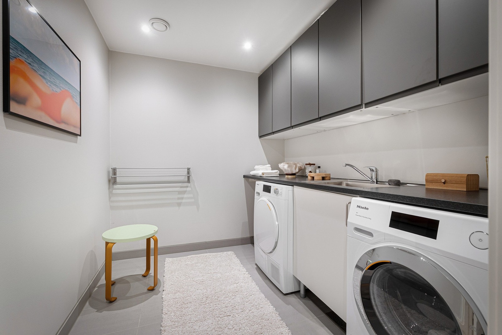 Vegg-i-vegg med badet ligger et praktisk vaskerom - et ypperlig rom for å få skittentøy og rot bort fra badene. Galleribilde