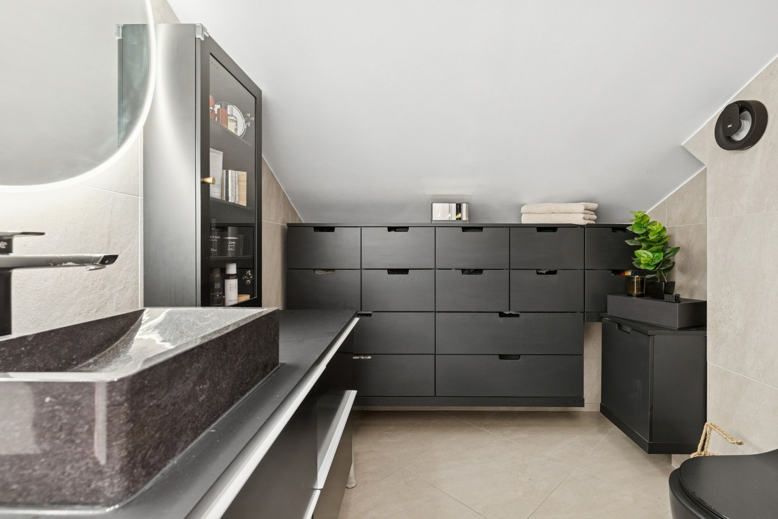 Baderom fra 2020 med servantinnredning med skuffeseksjon, laminat benkeplate, ovenpåliggende servant og innebygd/vegghengt toalett. Galleribilde