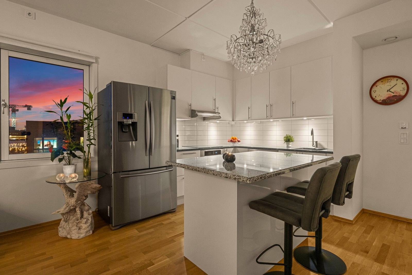 Kjøkkeninnredningen av merke HTH og har lyse fronter kombinert med benkeplater i stein, noe som gir et moderne og tidløst uttrykk Galleribilde