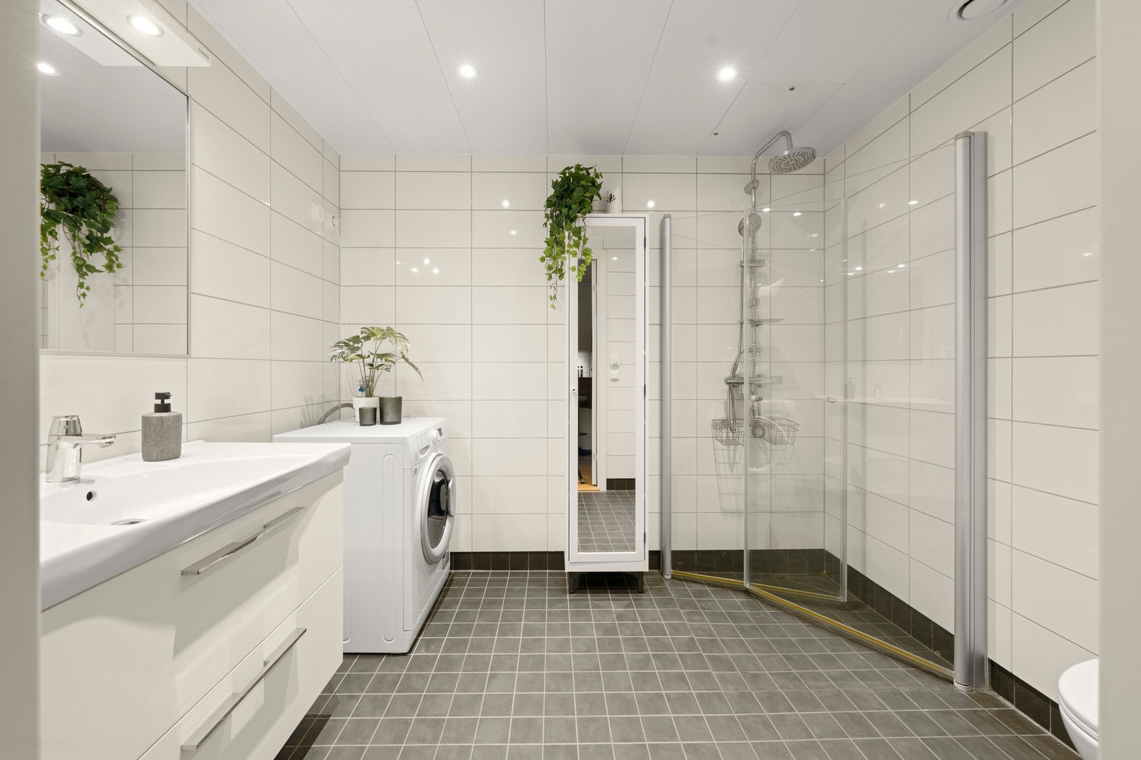 Pent og romslig bad med flislagte vegger og gulv i lyse og nøytrale toner Galleribilde