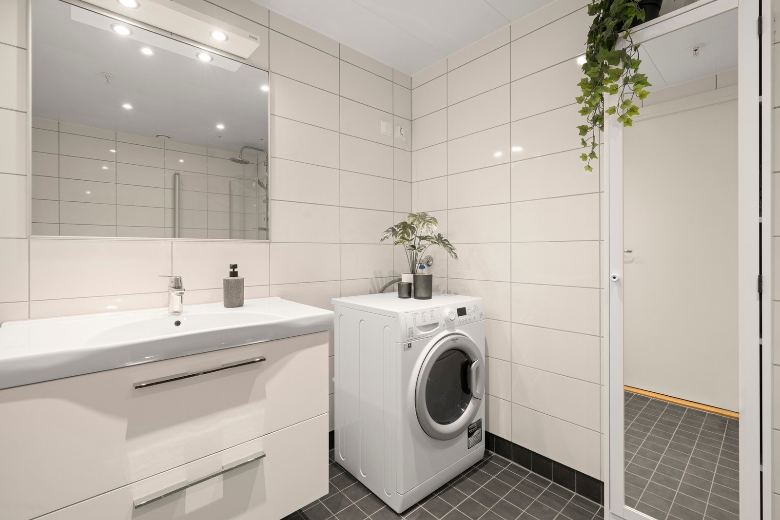 Badet er utstyrt med dusjløsning med glassvegger, servant og har opplegg for vaskemaskin Galleribilde