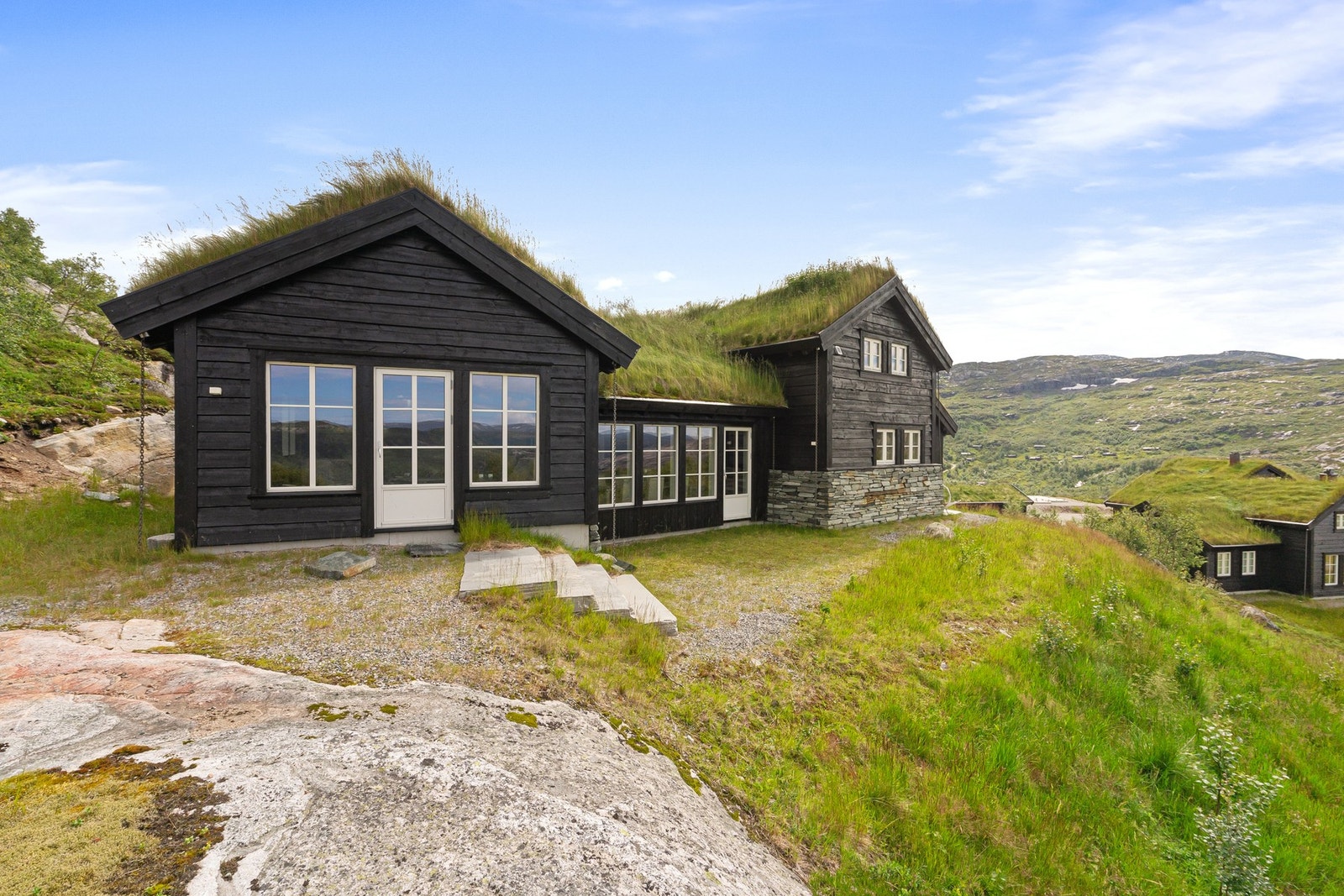 En solid hytte med villmarkspanel og torv på taket. Galleribilde