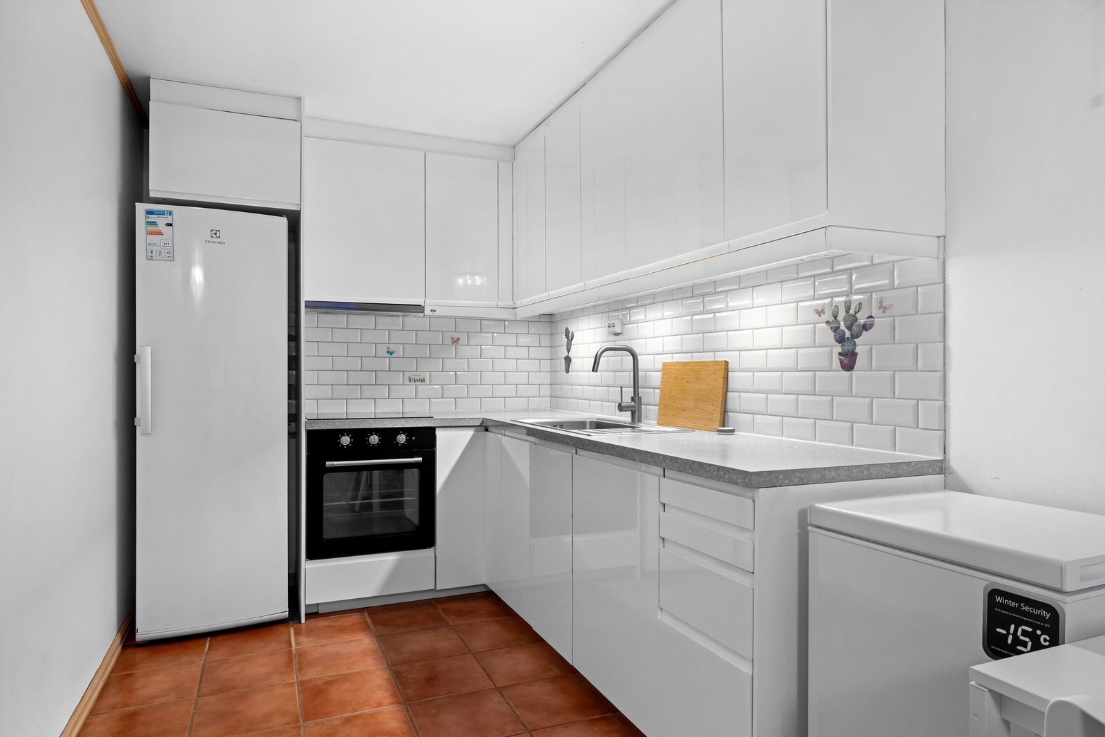 Kjøkkenet har innredning med glatte fronter og integrert stekeovn og oppvaskmaskin. Galleribilde