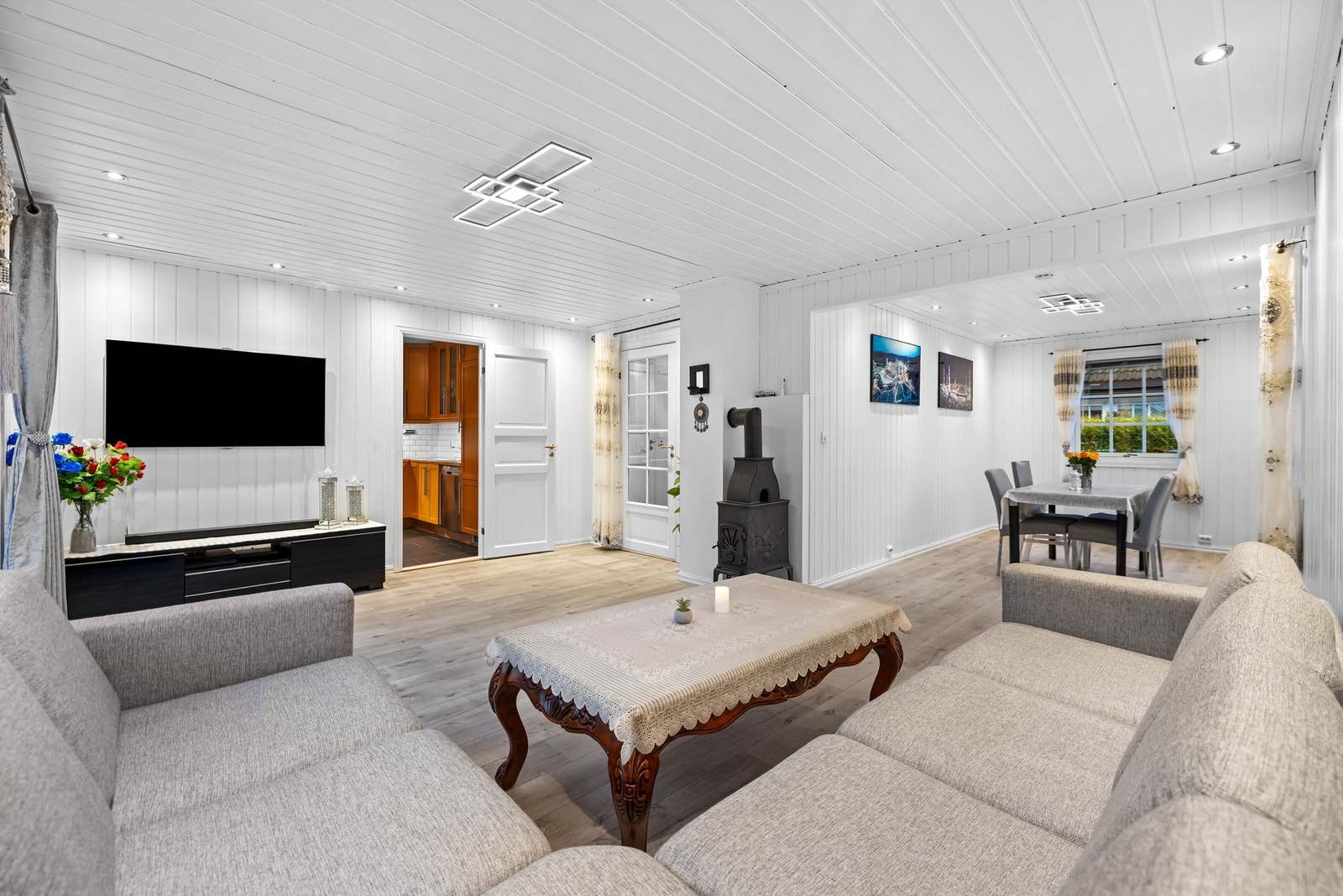 Stuen er lys og romslig, med downlights i taket og plass til både spisebord og sofagruppe Galleribilde