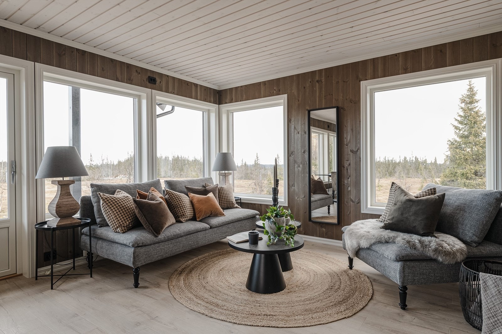 Inne i stua er det lyst og luftig med mange store vinduer, og terrassedør med glassfelt, noe som gir en unik romfølelse og slipper naturen inn i rommet. Galleribilde