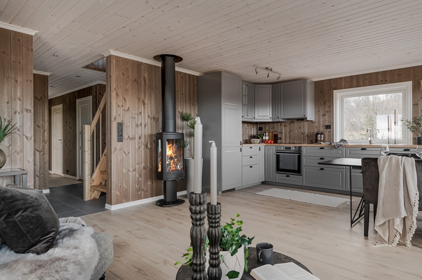 En stilfull peisovn med innsyn fra tre sider er tilkoblet stålpipe, noe som gir rask og lun varme til hytta. Galleribilde