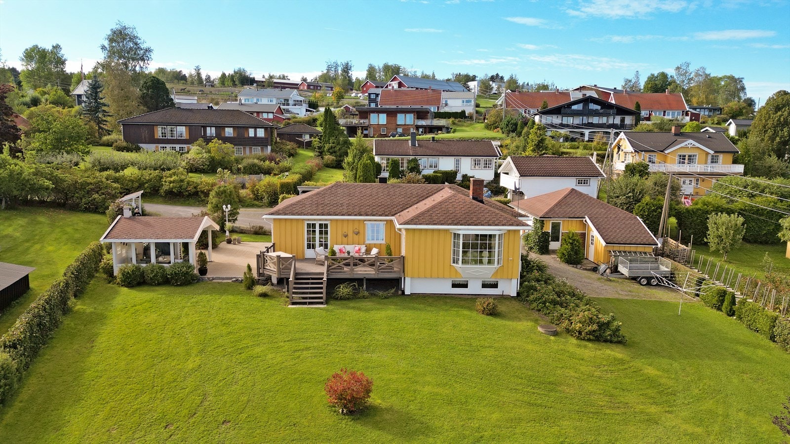 Stor tomt som er pent opparbeidet med plen og beplantning. Galleribilde