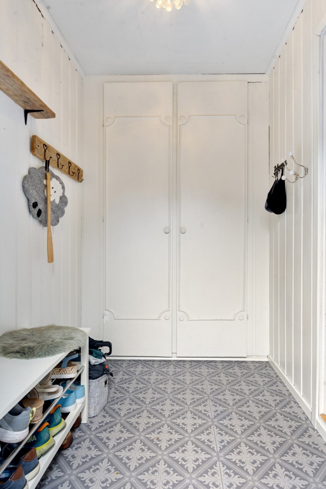 Velkommen inn! Her i den ytterste gangen møtes du av gulv med nyere gulvbelegg, vegger kledd i panel og et gammelt plassbygget garderobeskap. Galleribilde