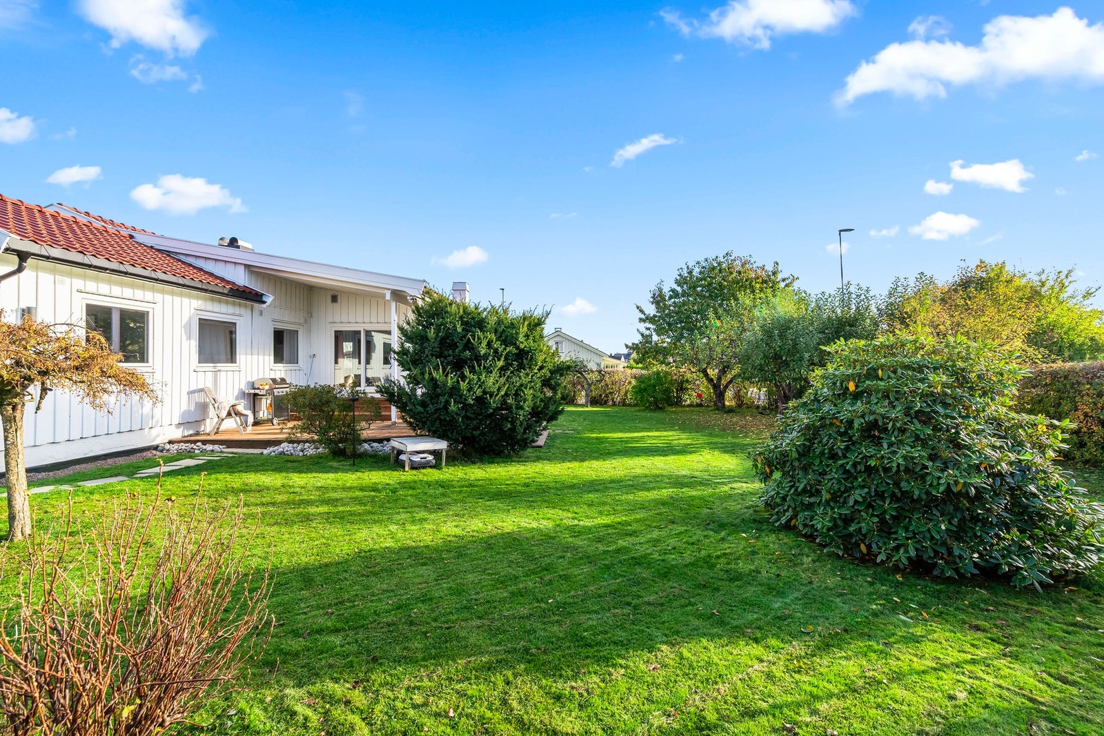 Hele familien vil trives i en flott hage, nydelig opparbeidet med blomsterbed og stor gressplen. Galleribilde