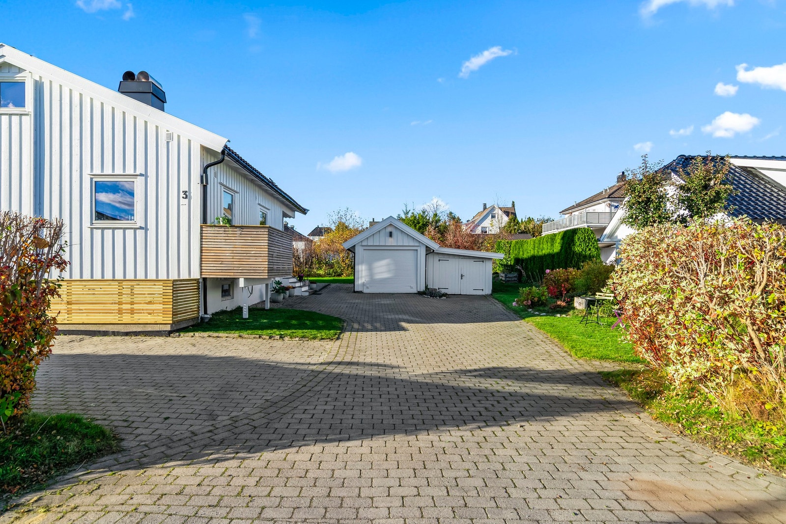 Opp til garasjen har tomten en steinlagt gårdsplass for ytterligere parkering. Galleribilde