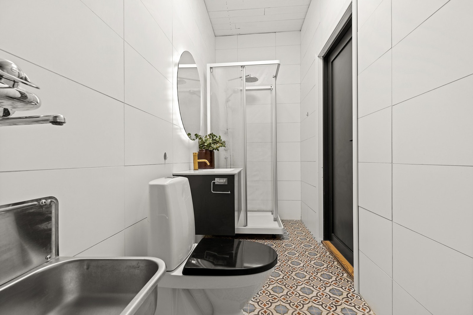 Badet i stall er innredet med utslagsvask, toalett, servant og et dusjkabinett. Galleribilde