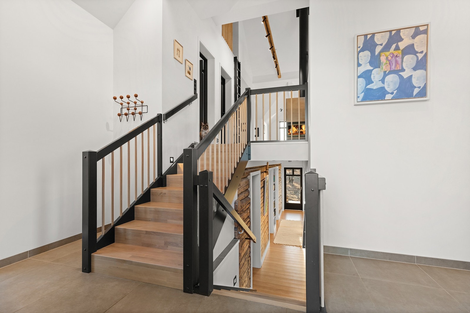 En malt/lakkert tretrapp med trinn og opptrinn i eik går mellom etasjeplan. Galleribilde