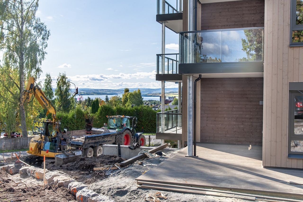 Stor delvis overbygd hjørneterrasse med utsikt. Uteområdet er ferdigstillelse og grønn plen kommer til våren. Foto fra tidligere i høst. Galleribilde