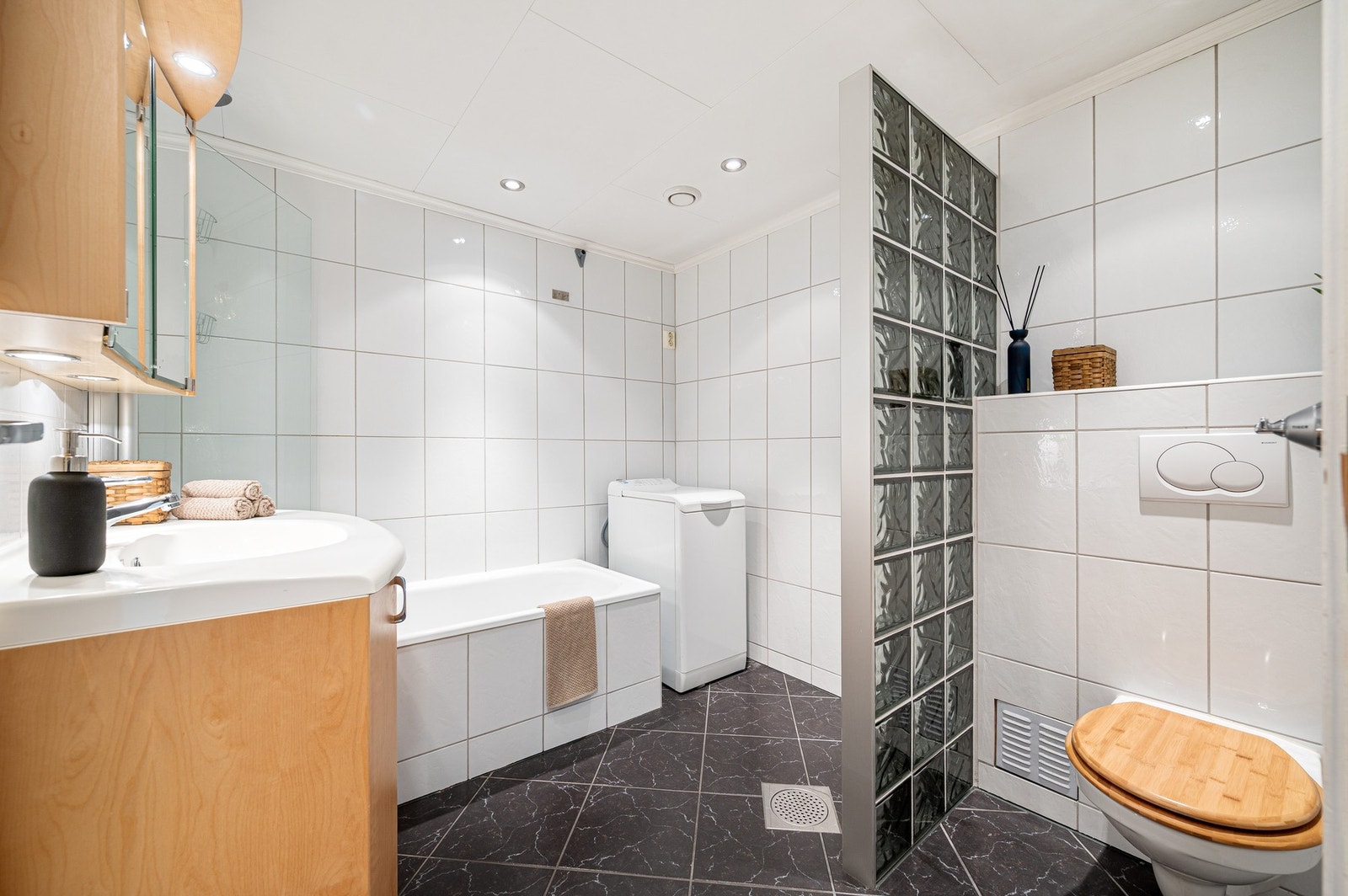 Badet er innredet med
badekar med dusjgarnityr og veggmontert toalett. Galleribilde