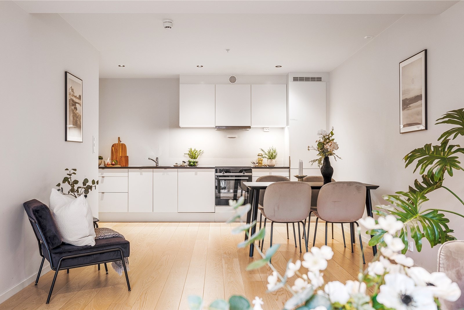 Kjøkkenet fra 2019 er i en åpen løsning med stuen og har parkett på gulvet, samt malte, slette flater på vegger og i tak. Galleribilde