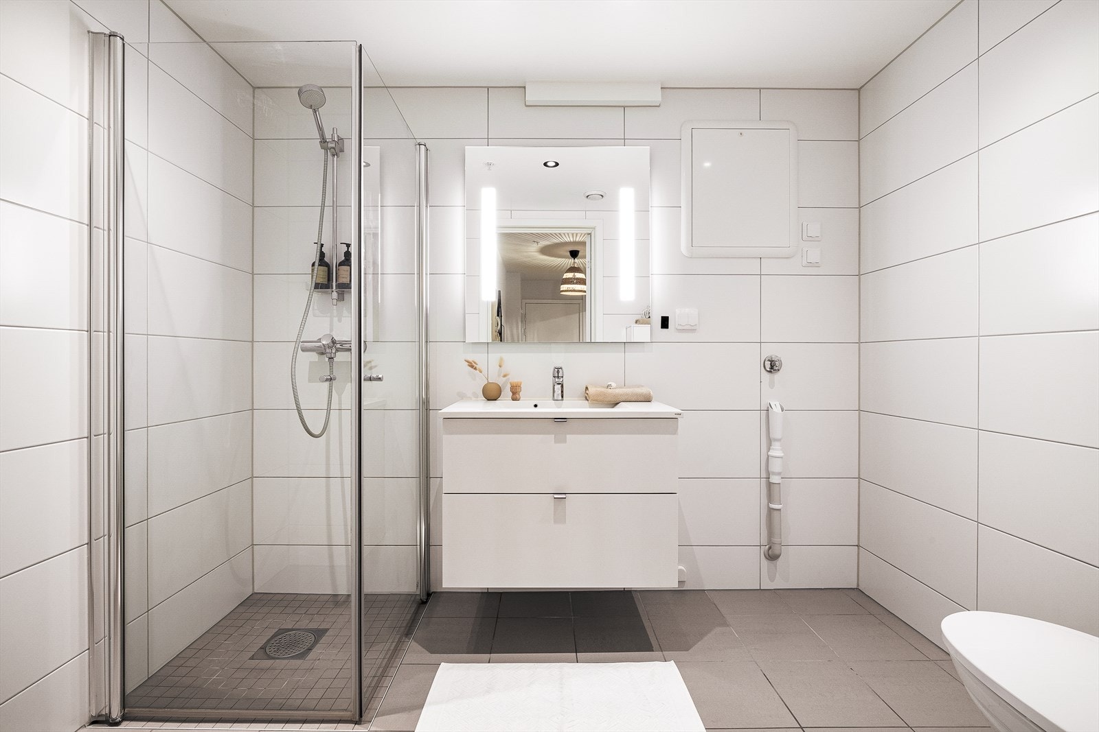 Det helflisede og lekre badet er fra 2019 og er innredet med en nedfelt servant, veggmontert toalett og et dusjhjørne med dusjvegger. Galleribilde