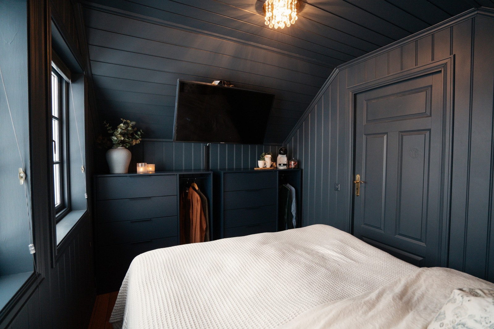 Rommet er malt i en stilig og mørk blåfarge Galleribilde