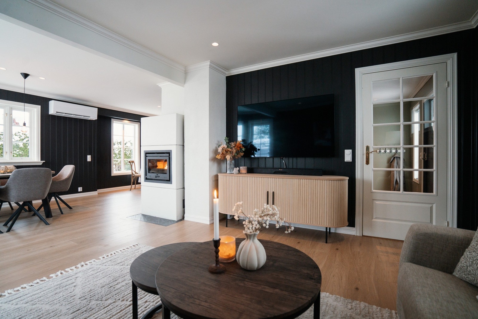 Stuen varmes effektivt opp med en moderne peisovn i kombinasjon med varmepumpe, som gir behagelig inneklima året rundt Galleribilde