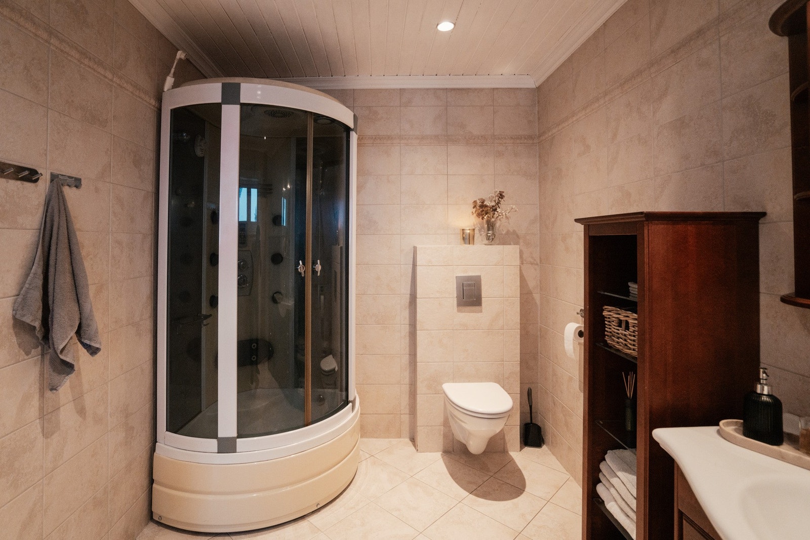 Rommet er utstyrt med innredning med nedfelt servant, veggmontert toalett og dusjkabinett Galleribilde