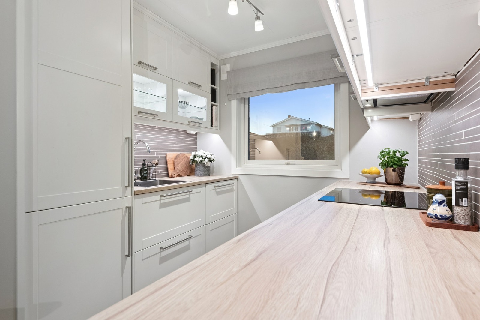 Lyst og innbydende kjøkken med mye skap og benkeplass. Integrerte hvitevarer. Galleribilde