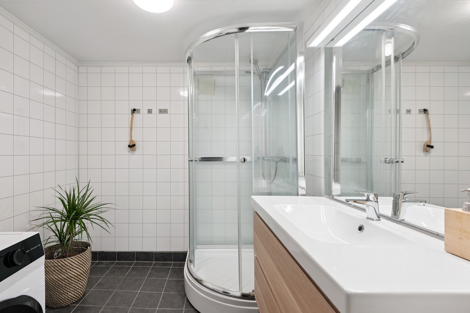 Flislagt bad med opplegg for vaskemaskin. Galleribilde