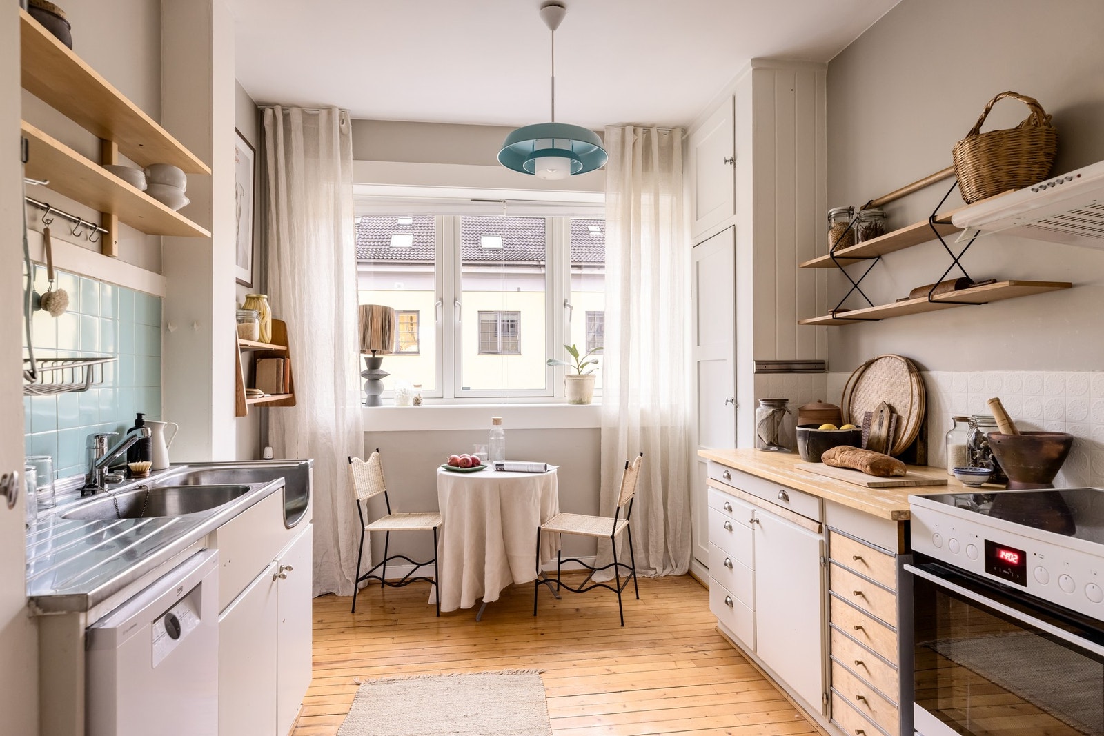 Flott seperat kjøkken innredet med oppvaskmaskin, kjøleskap med fryser og komfyr. Galleribilde