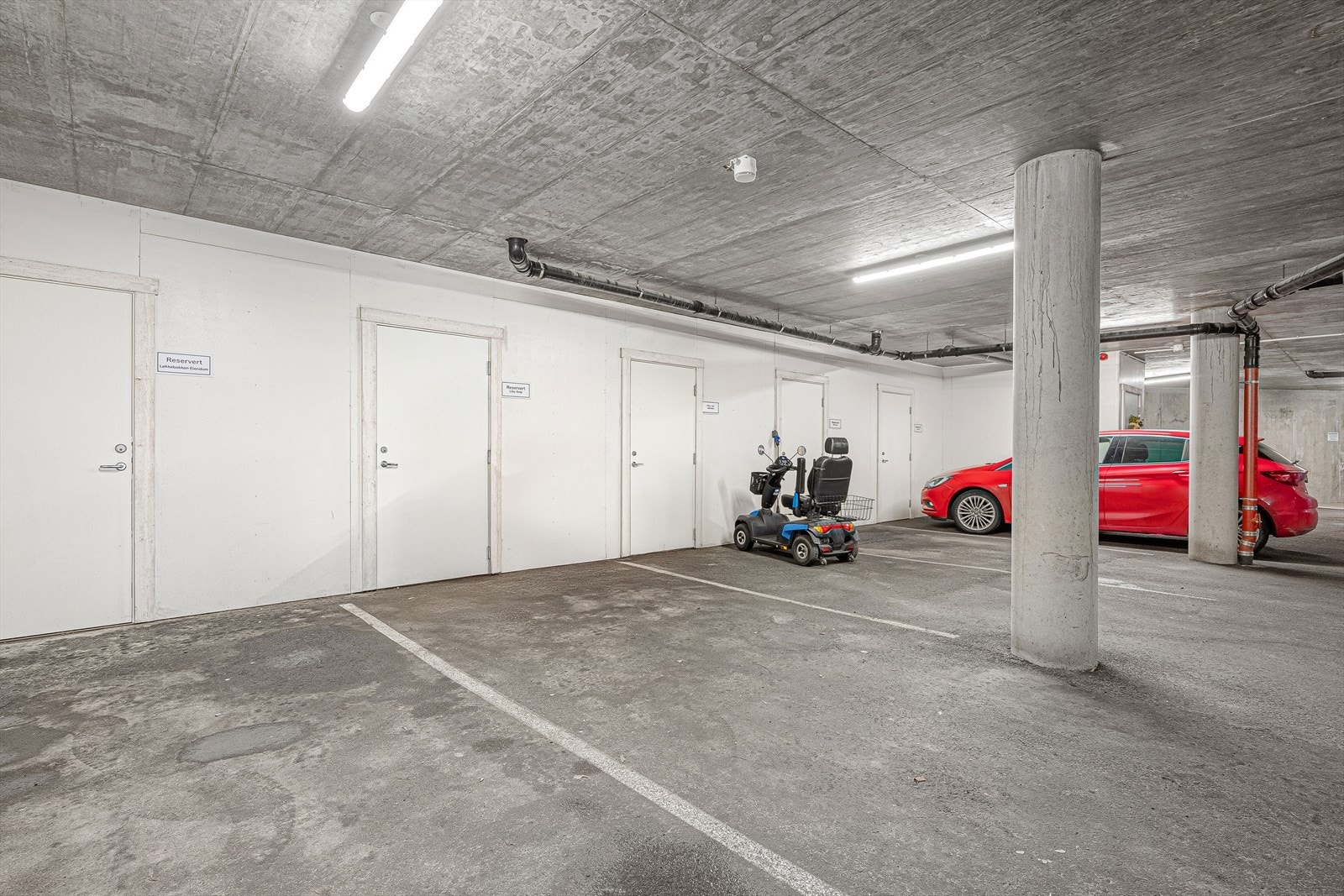 Egen, merket biloppstillingsplass i felles garasjeanlegg. Det er i tillegg noen gjesteparkeringer for sameiet. Galleribilde