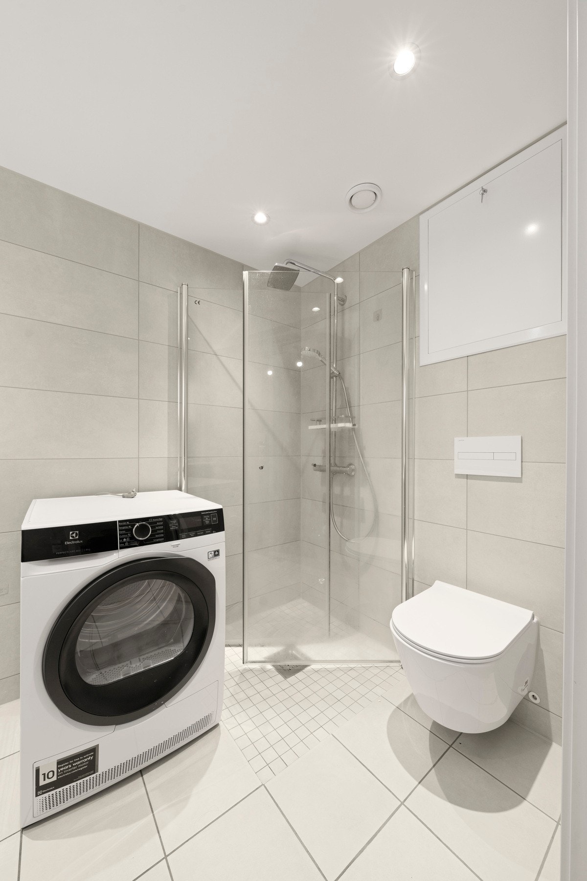 Badet er innredet med nedsenket dusjhjørne, vegghengt toalett, servant med skuffer, samt speil med integrert lys. Det er opplegg for vaskemaskin. Galleribilde