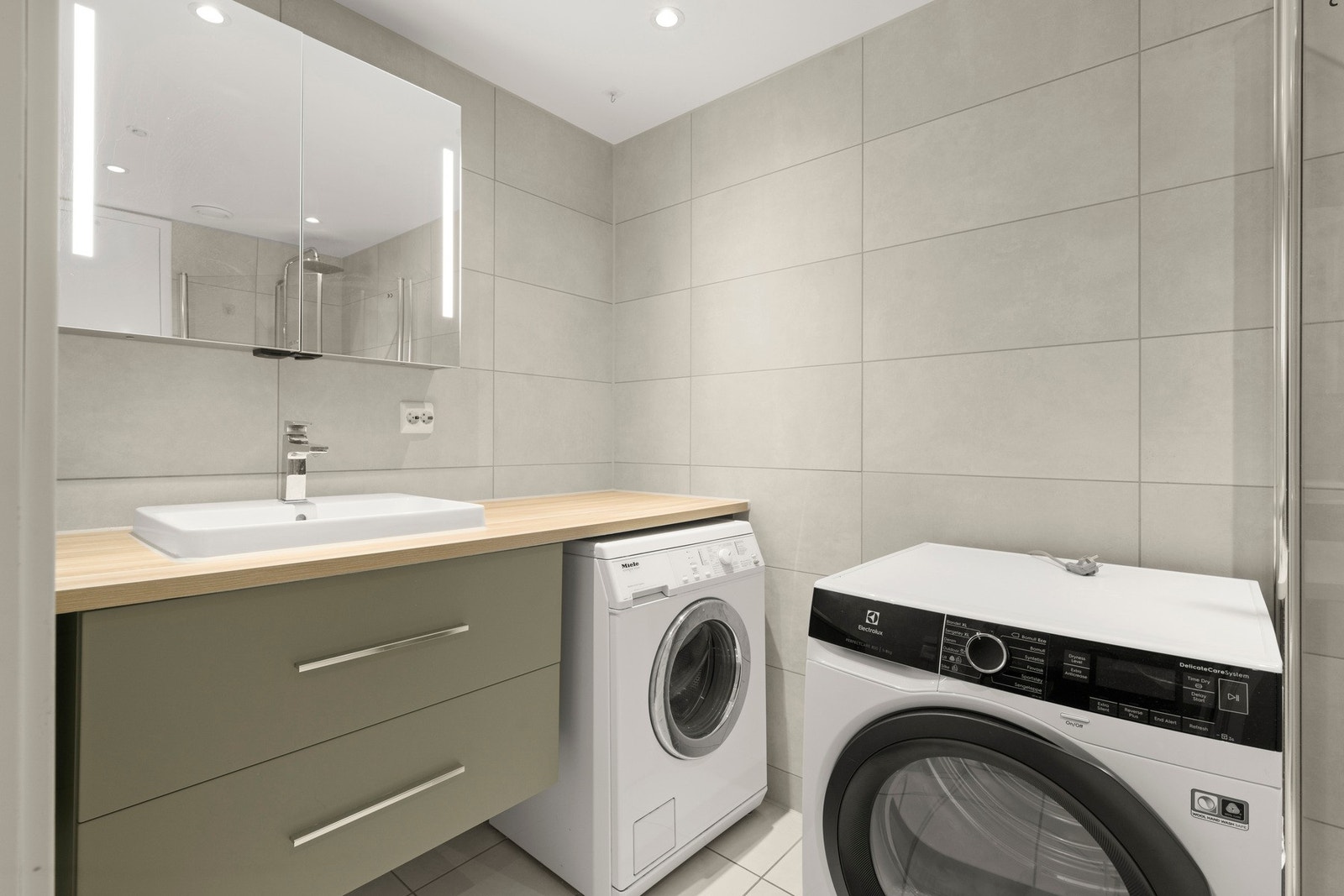 Pent, flislagt baderom med varmekabler i gulv og downlights i himling Galleribilde