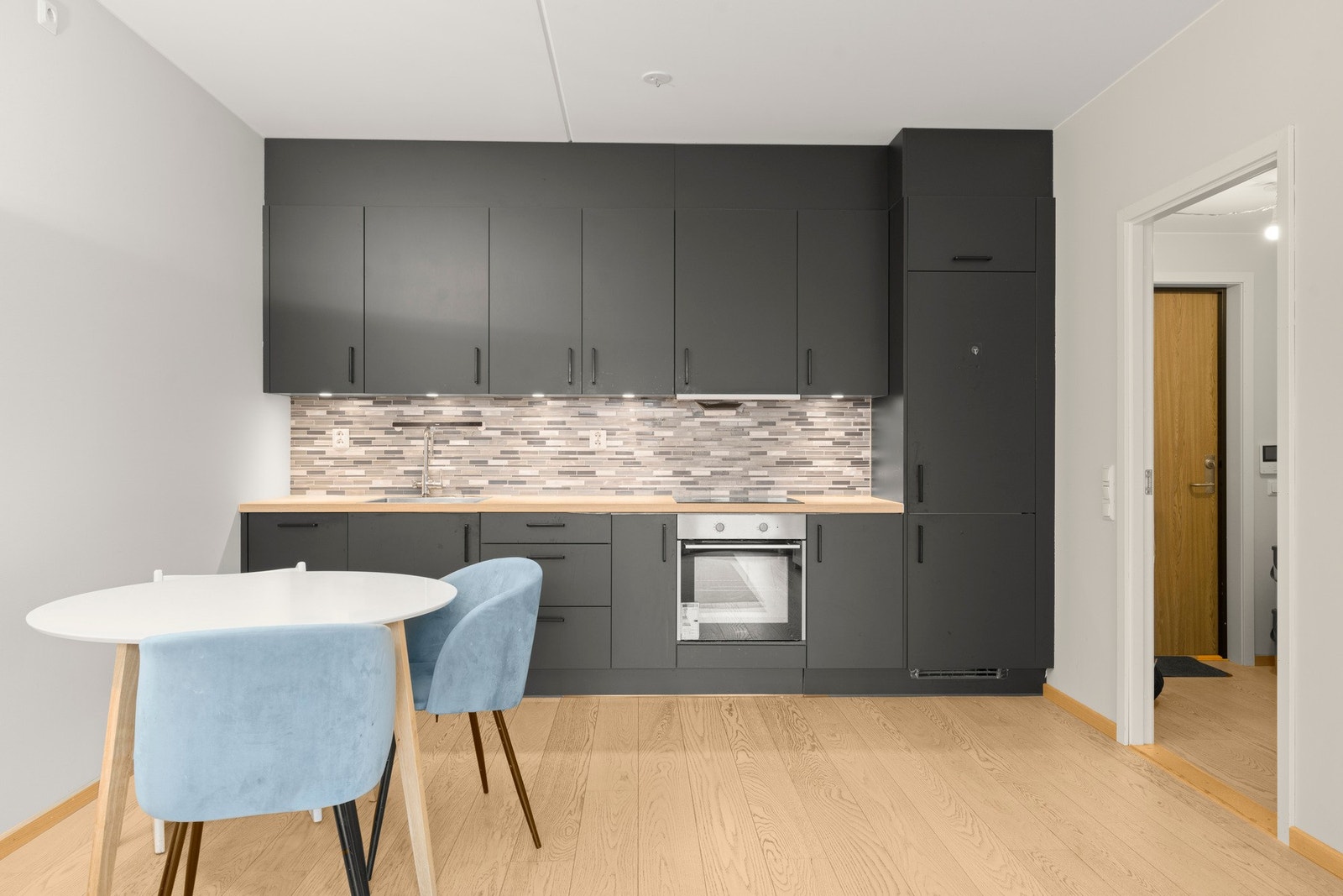 Kjøkkenet er stilrent og levert av merket Crown Imperial, med slette fronter og et moderne uttrykk Galleribilde