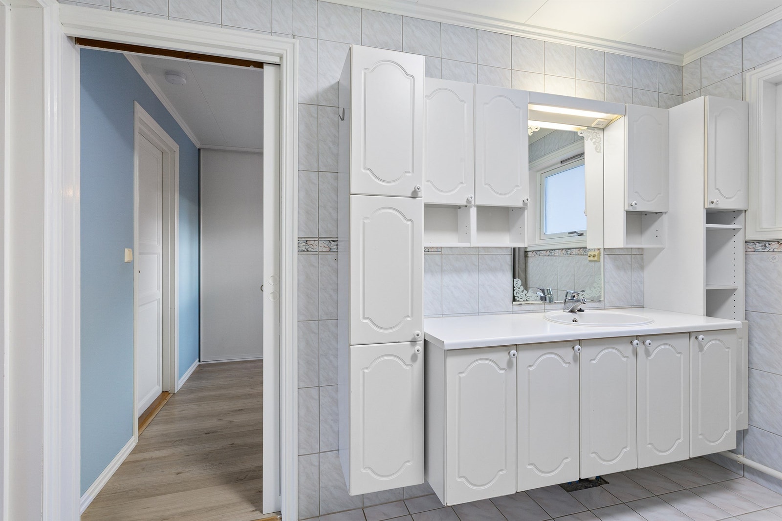 Flislagt bad med gulvvarme. Innredet med vegghengt servantinnredning med dører og ovenpåliggende servant. Galleribilde