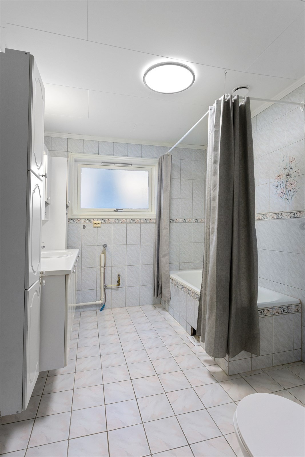 Badekar og gulvstående toalett. Opplegg for vaskemaskin. Galleribilde