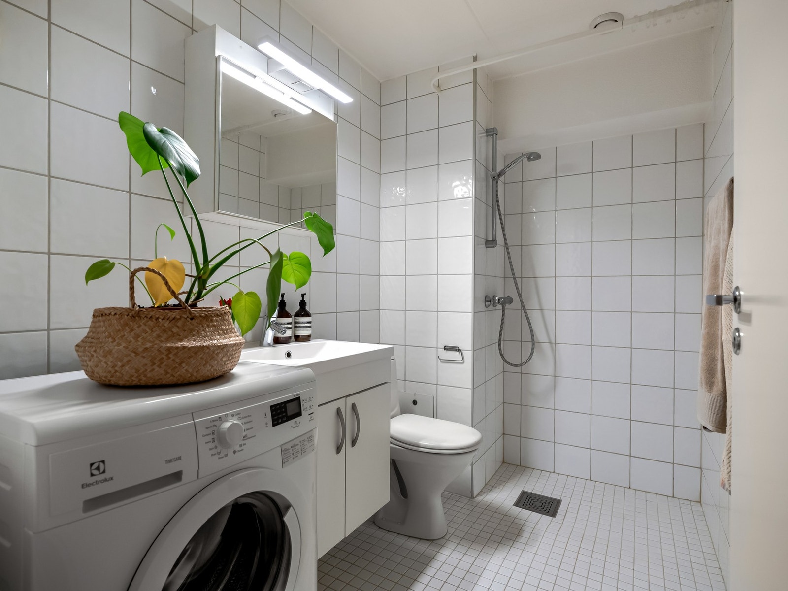 Badet er innredet med toalett, servantskap, speil på vegg og dusjsone. Galleribilde