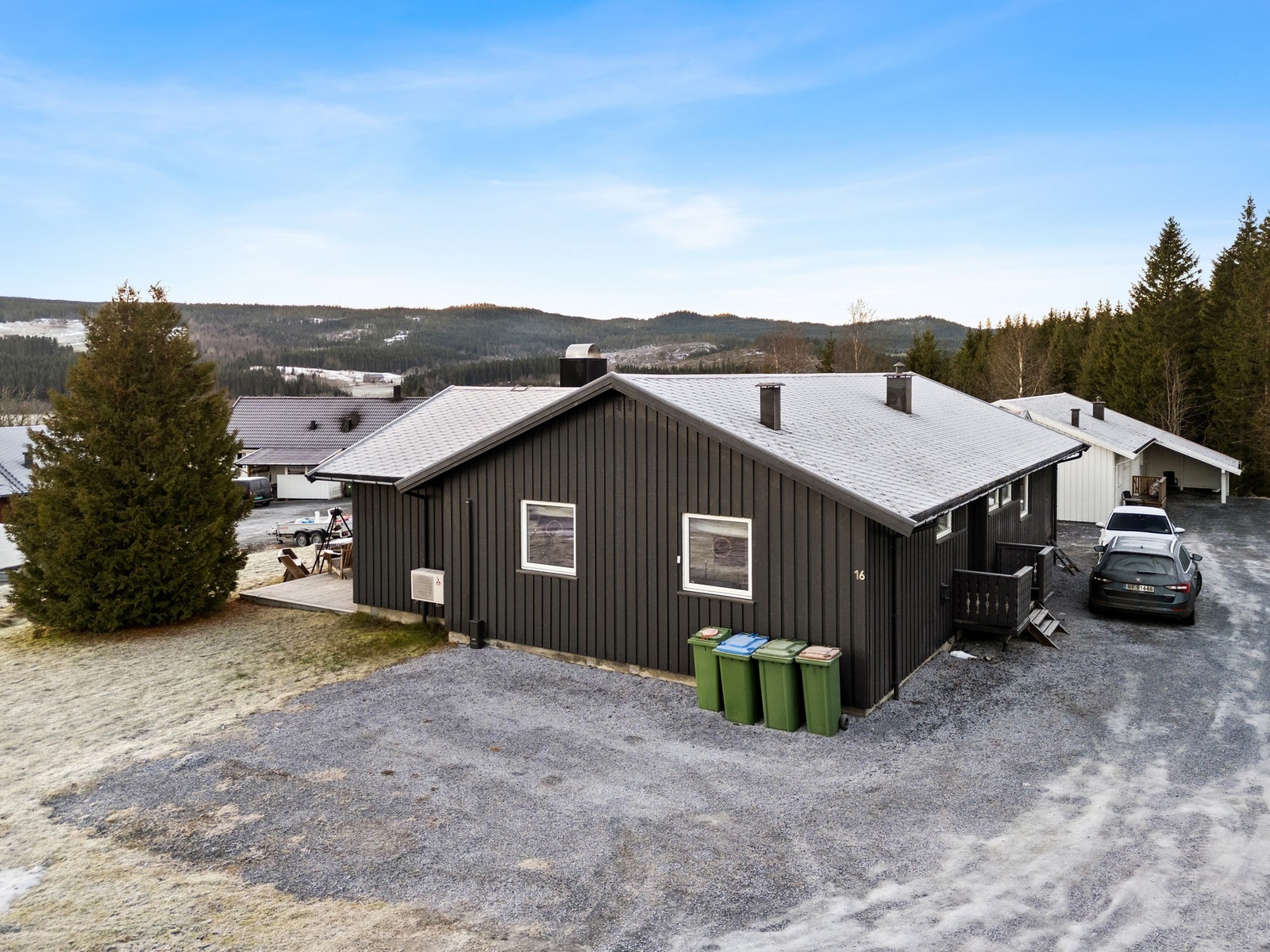 Gårdsplass på siden av huset og garasje. Galleribilde